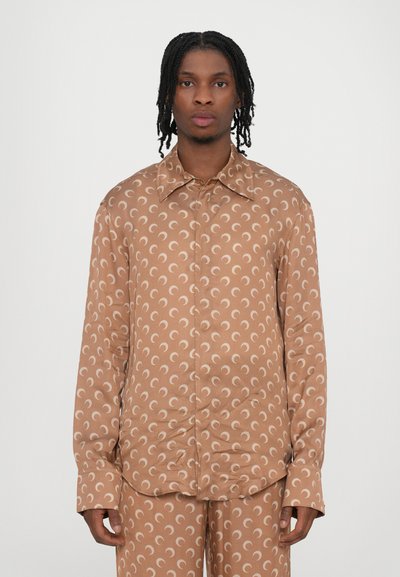 Brown patterned long-sleeve shirt featuring crescent shapes, a pointed collar, and button closure. Smooth fabric with a relaxed fit.