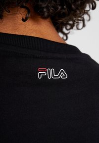 Felpa nera con colletto a costine e un logo Fila colorato ricamato sul retro, con dettagli in bianco e rosso.