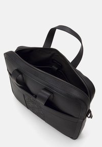 Zwarte leren aktetas met een getextureerd frontpaneel, dubbele handvatten aan de bovenkant en een ritssluiting. Ruime binnenkant met een gladde voering.