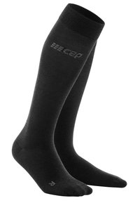 Calze a compressione nere fino al ginocchio con una textura liscia e punta rinforzata, dotate di un logo grigio sul lato.