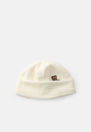 Gorro branco canelado com aba dobrada, apresentando um pequeno rosto de urso bordado na frente. Textura suave, design simples.