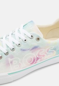 Canvas sneakers i pastellfärger med ett akvarellmönster. Har vita snören, silveröglor och en logotyp "BOSS" på sidan.