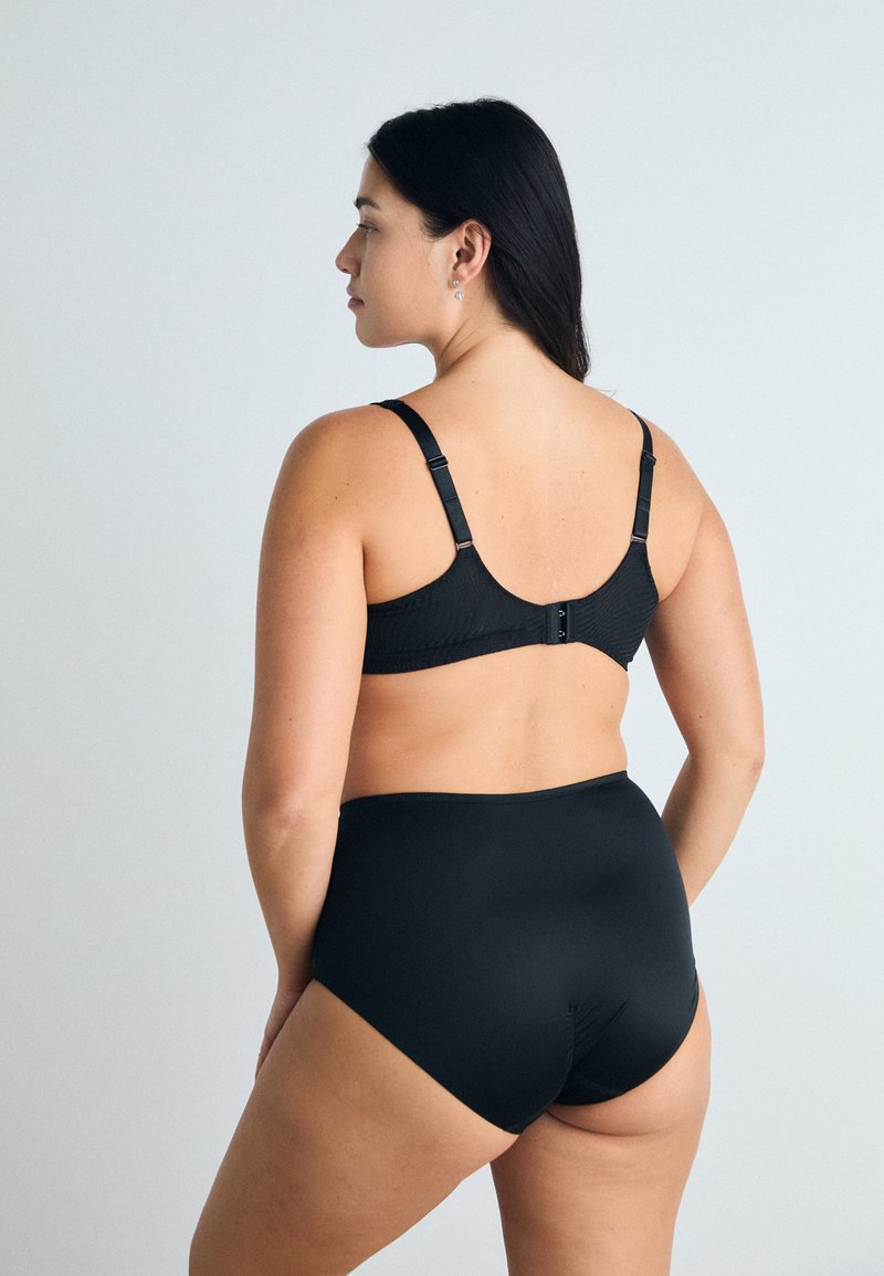 Schwarzes Lingerie-Set mit einem strukturierten BH mit verstellbaren Trägern und einem hochgeschnittenen passenden Unterteil. Glatte Stoffe und minimale Hardware.