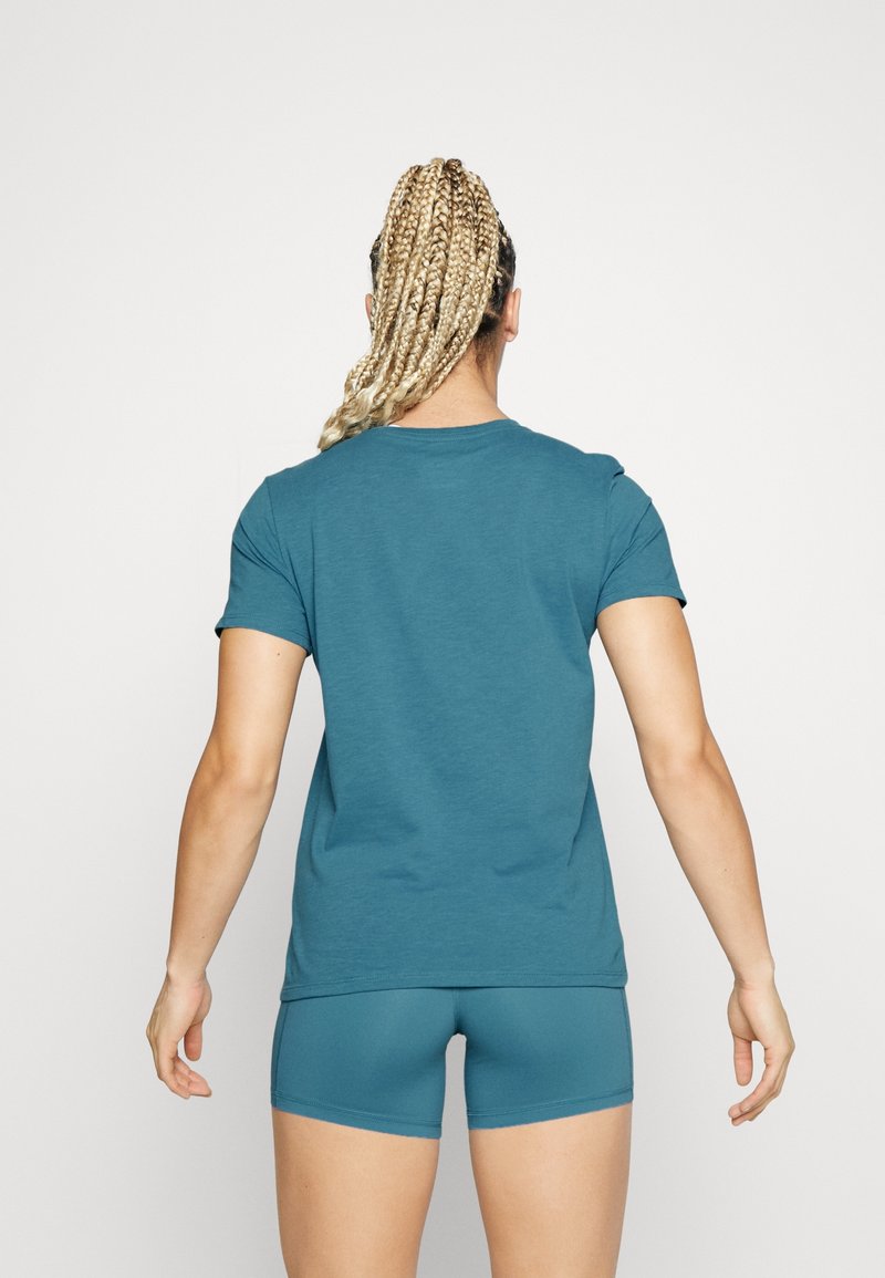 Teal athletic t-shirt with short sleeves and a round neckline, paired with matching high-waisted shorts, viewed from the back.