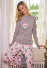 Haut gris à manches longues présentant un chien de dessin animé avec des concombres sur les yeux et un chapeau rose, associé à un pantalon de pyjama rose avec le même motif.