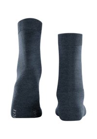 Calzini grigi scuri con polsini a coste, texture liscia e design senza cuciture. Presentano un logo sul lato esterno inferiore del calzino sinistro.