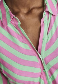 Chemise à manches courtes avec des rayures horizontales rose et verte, en coton, dotée d'un col classique et d'une texture légère.