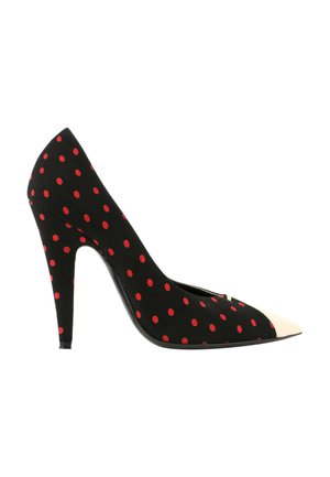 Chaussure à talon haut noire à pois rouges avec un bout pointu blanc contrastant, vue de côté.