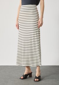 Stripete maxiskjørt i kremfarge med tynne svarte horisontale striper. Laget av mykt stoff, har en flytende design ned til ankler.