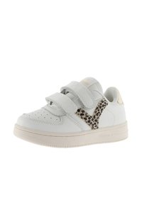 Sneaker blanche avec deux straps Velcro, mettant en avant un accent en imprimé léopard sur le côté, semelle en caoutchouc et zone perforée à l'avant.