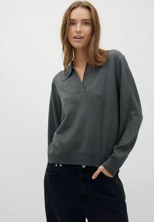 Gray pullover with a collar and a V-neckline, made from soft fabric. Long sleeves and relaxed fit, paired with dark denim jeans.