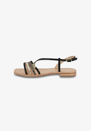 Sandalias planas negras con múltiples correas horizontales, incluyendo acentos brillantes. Presentan una plantilla de cuero natural y un pequeño tacón.