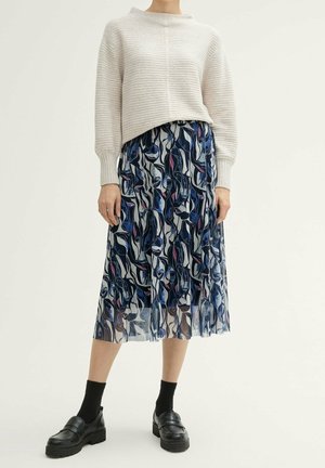 Pull côtelé gris clair avec un col montant, associé à une jupe fluide à motif navy présentant des designs floraux abstraits en rose et bleu.
