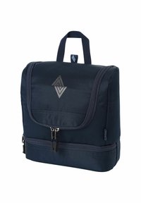 Sac à dos bleu marine en tissu texturé, avec un rabat à l'avant, des compartiments zippés et une poignée supérieure. Présente un logo en forme de diamant avec une finition métallique.