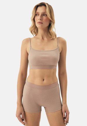 Hellbrauner, gerippten Bralette mit dünnen Trägern und passender Shorts. Der Stoff hat eine weiche Textur und ein figurbetontes, nahtloses Design.