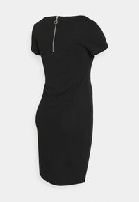 Musta istuva mekko lyhyillä hihoilla, teksturoitu materiaali, drapattu sivuyksityiskohta ja takaläppäkiinnitys.