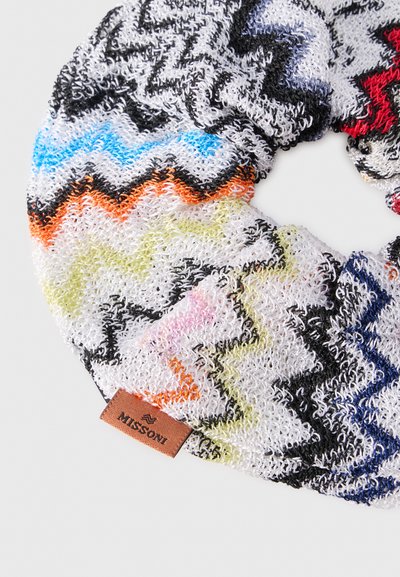 Πλεκτή λαστιχάκι Missoni με πολύχρωμο ζιγκ-ζαγκ μοτίβο σε μπλε, πορτοκαλί, μαύρο, κόκκινο και κίτρινο σε λευκό φόντο.