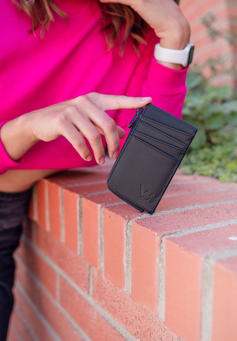 Black leather cardholder with multiple card slots and a zippered compartment, featuring a textured finish and embossed logo detail.