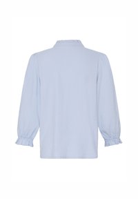 Blouse bleu clair à manches longues avec col montant volanté et poignets volantés, vue de dos sur fond blanc.