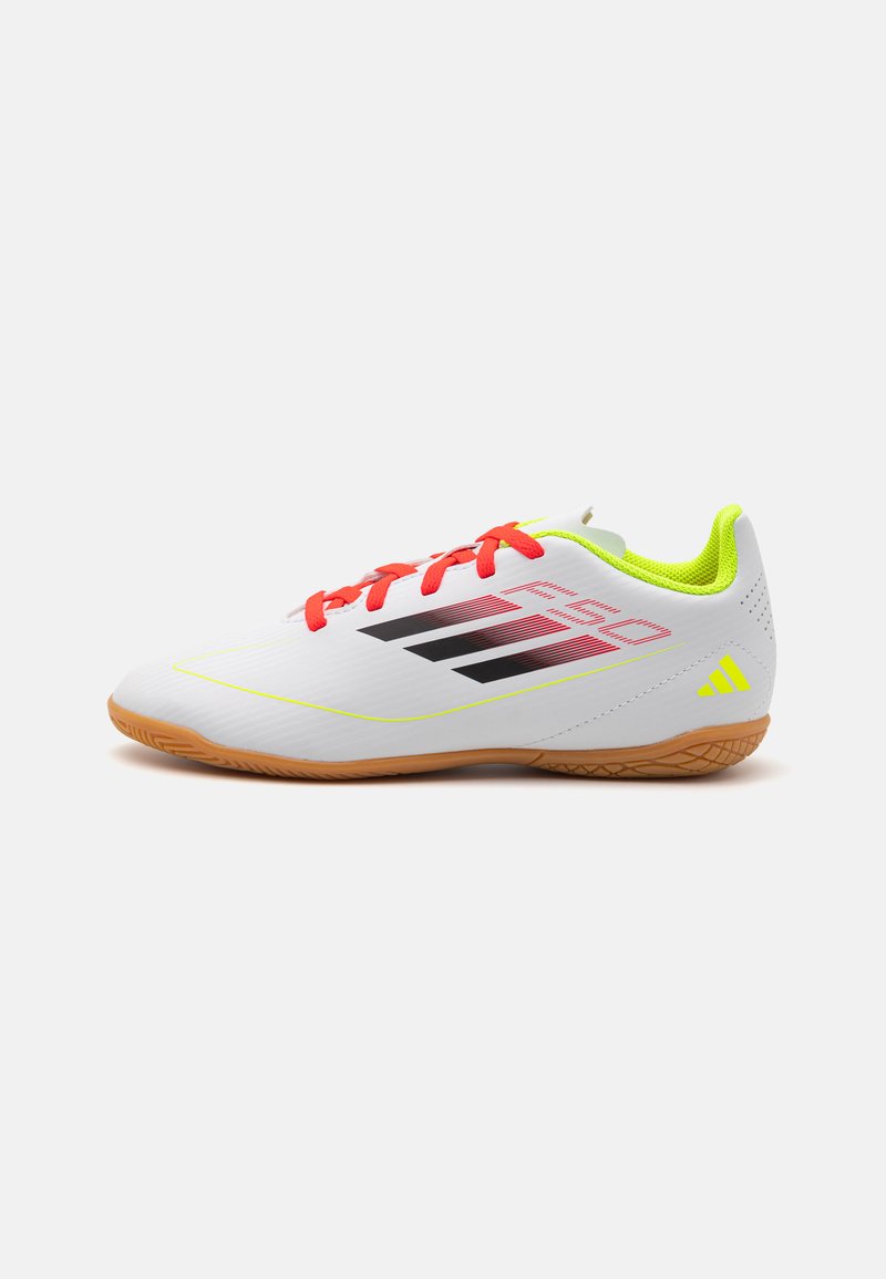 Scarpe da ginnastica bianche con una finitura testurizzata, accenti gialli brillanti, lacci rossi e strisce nere. Presentano una suola in gomma.