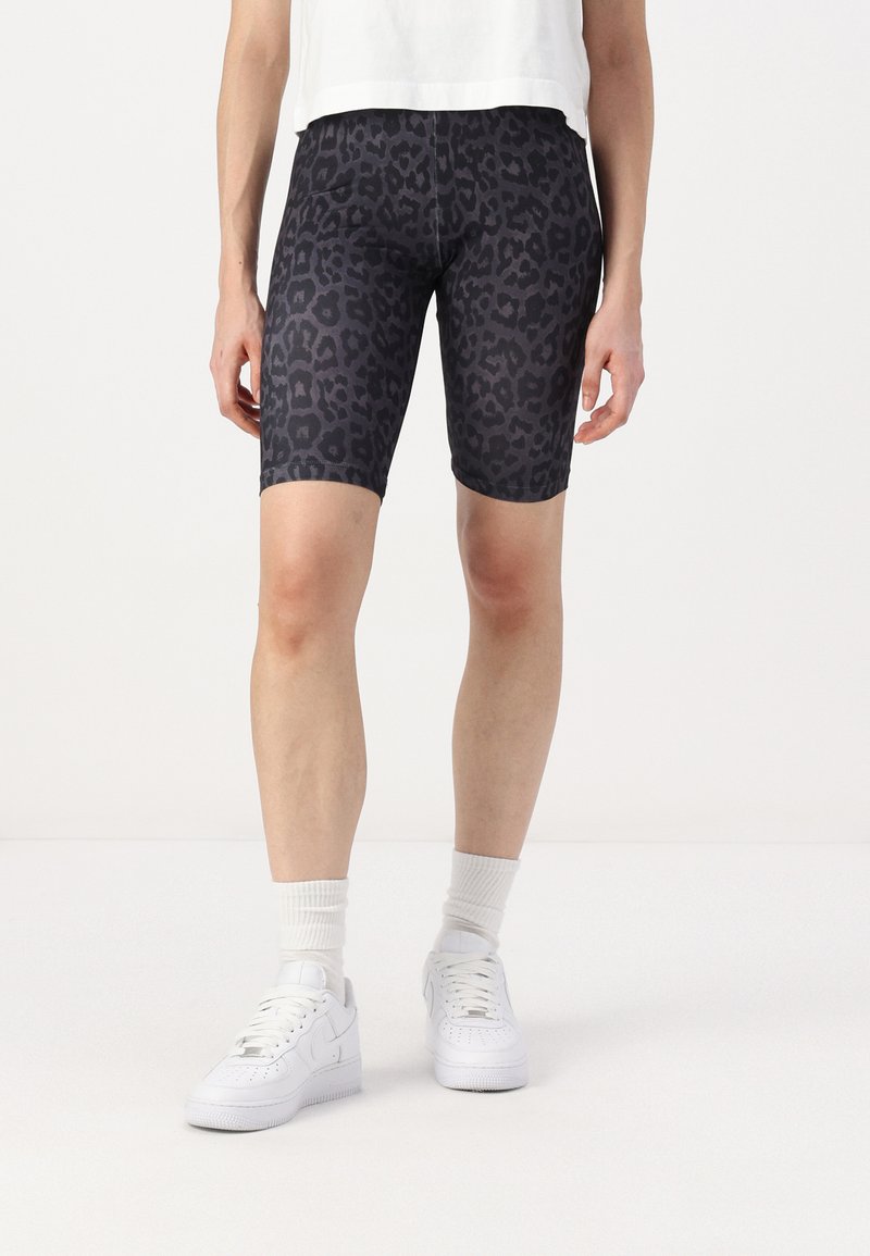 Shorts de vélo en tissu extensible avec un imprimé léopard noir, longueur mi-cuisse, dotés d'une taille élastique et d'une texture lisse.