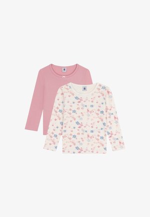 To lange ermelige topper: en ensfarget pastellrosa med en sløyfedetalj, den andre hvit med et blomster mønster i rosa og blå nyanser.