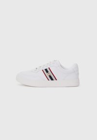 Sneaker bianco con tomaia texture, caratterizzata da strisce orizzontali nere e rosse, design con lacci e soletta in gomma piatta. Dettaglio del logo dorato presente.