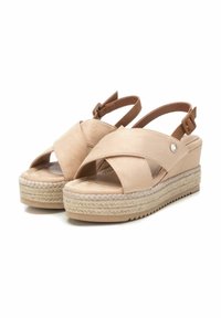 Sandalias de cuña beige con correas cruzadas, hechas de ante, con una planta intermedia de yute trenzado y un pequeño botón decorativo en el lateral.
