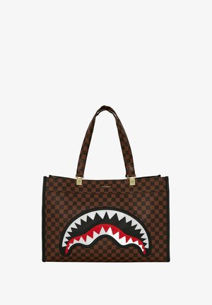 Bolso tote de cuadros marrones con un diseño de boca de tiburón negra que presenta dientes rojos y blancos. Los acentos de hardware dorado realzan la forma estructurada.