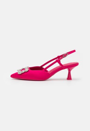 Jasnoróżowy sandał na obcasie typu kitten heel, z zakrytą piętą, szpiczastym noskiem, podwójnymi paskami, regulowaną klamrą oraz ozdobną klamrą z kryształków na froncie.