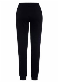 Sorte sweatpants med en blød tekstur, elastisk talje, tapered ben og ribbede manchetter. Ingen synlige mønstre eller accenter.