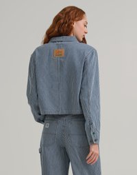 Giacca di jeans a righe con design corto, caratterizzata da un'etichetta Lee Crayola, polsini con bottone e dettagli hardware delicati in righe blu e bianche.