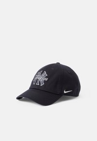 Tamna plava pamučna bejzbol kapa sa izvezenim Yankees logotipom u bijeloj boji i malim bijelim Nike svušom sa strane.
