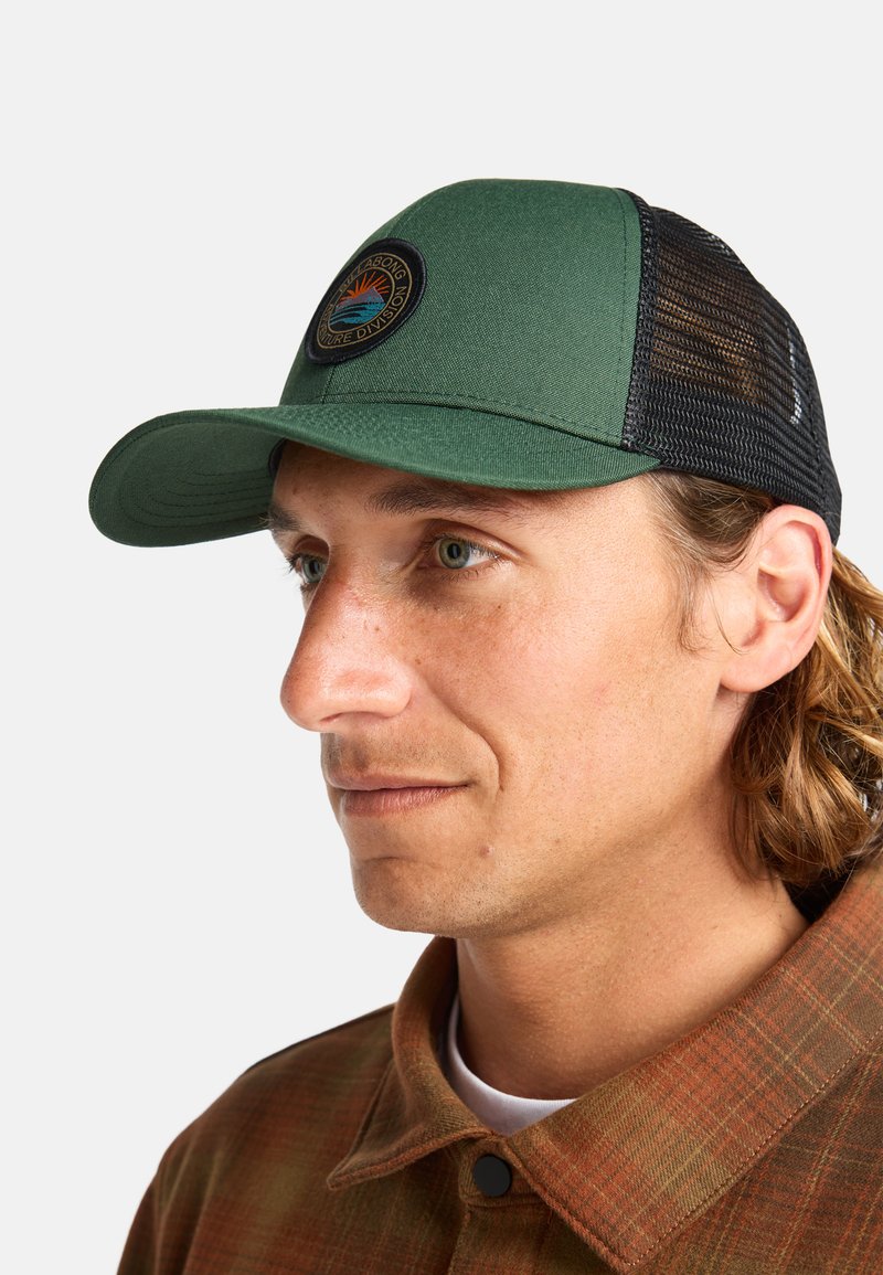 Green and black cap with a curved visor and mesh back. Features a circular logo with a sun and waves in the center. Textured fabric.