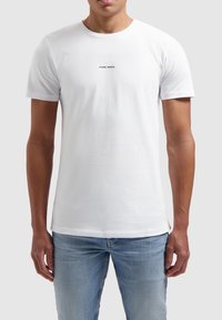 Witte t-shirt met korte mouwen van katoen, met een ronde halslijn en een zwarte tekstprint "PURE PATH" op de borst.