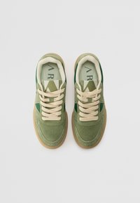Groene suède sneakers met crèmekleurige veters, voorzien van een mesh-tong en een tan rubberen zool. Inclusief donkergroene accenten en logo-detail op de tong.