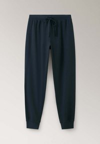 Pantalon de jogging noir avec ceinture élastique et cordon, jambes fuselées et chevilles resserrées sur un fond clair uni.