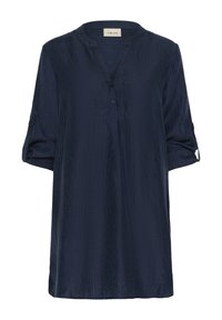 Tumši zils, īsām piedurknēm tunika ar mandarina tipa apkakli, pogu aizdari un teksturētu audumu. Iezīmētas sarullētas piedurknes ar poga lentām.