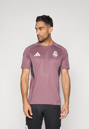 Bordeauxrode sport T-shirt met zwarte accenten, korte mouwen, een ronde hals en een Real Madrid-logo op de borst. Gemaakt van lichtgewicht stof.