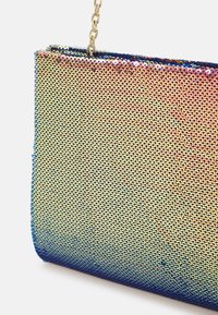 Pochette rectangulaire recouverte de sequins irisés dorés et bleu marine, avec une fine bandoulière chaîne dorée.