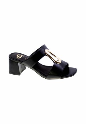 Mule donna nera con punta aperta, tacco a blocchetto e grande fibbia ovale dorata sulla larga fascia sopra il piede.