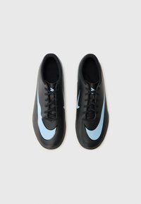 Fekete focicipők sima felülettel, világoskék Nike logóval és fekete fűzővel, a teljesítmény és agilitás érdekében tervezve.