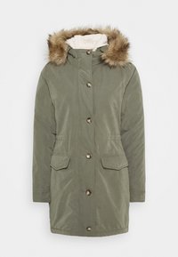 Olivgrön parka-jacka med en huva i konstig päls, knapprad framtill, två framfickor och en mjuk kramfärgad foder. Vattenavvisande material.