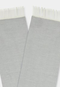 Jasnoszary szalik z wzorem jodełki, z frędzlami na końcach dla dodania tekstury i detalu. Miękka tkanina zapewnia wygodę i ciepło.