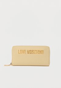Μπεζ πορτοφόλι με φερμουάρ και απαλό ύφασμα, με ανάγλυφα χρυσά γράμματα "LOVE MOSCHINO" στο μπροστινό μέρος. Μινιμαλιστικός σχεδιασμός με στρογγυλεμένες άκρες.