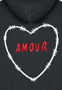 Felpa nera con cappuccio caratterizzata da un contorno a cuore ricamato in bianco, al centro del quale è presente il testo "AMOUR" in rosso, che mostra un design di cucitura testurizzato e a strati.