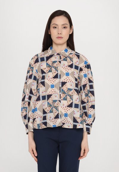 Multicolored blouse featuring a geometric patchwork design with floral accents, button-down collar, and long sleeves made of lightweight fabric.