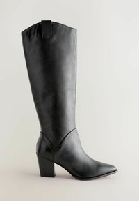 Botte en cuir noir jusqu'au genou avec un bout pointu et un talon épais. Elle présente une texture lisse et une petite languette à l'arrière.