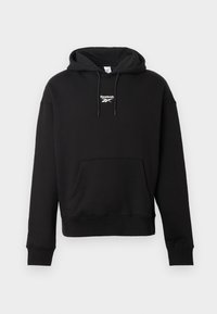 Felpa nera con cappuccio realizzata in morbido cotone, presenta una tasca a marsupio frontale, cappuccio con lacci e un logo Reebok bianco sul petto. Vestibilità standard.