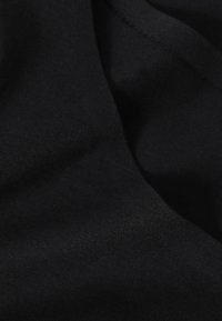 Tissu en coton noir à texture lisse, présentant une finition douce et mate sans motifs ni éléments visibles.